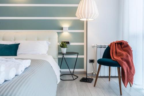 a bedroom with a bed and a chair and a lamp at 4 Star Bologna Train Station - Self Check-In in Bologna