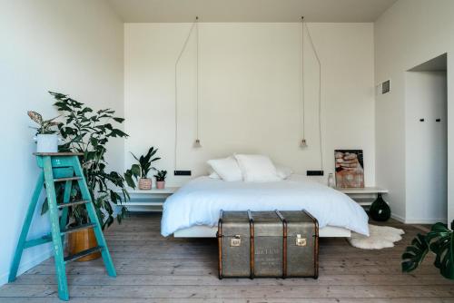 a bedroom with a bed with a ladder and a stool at Chambre d'Amis by Alix in Ghent