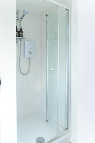 a shower with a glass door in a bathroom at The Nook in West Mersea
