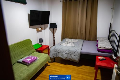 Habitación pequeña con cama y sofá en The Zen Apartment Athens, en Atenas