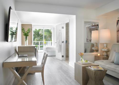 a white living room with a desk and a couch at Grand Beach Hotel Surfside West in Miami Beach