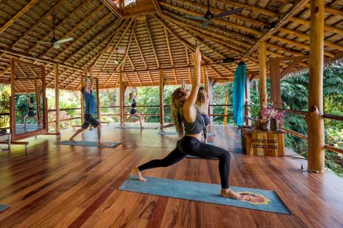 a woman in a yoga class in a pavilion at Selva Armonia Immersive Jungle Resort in Uvita