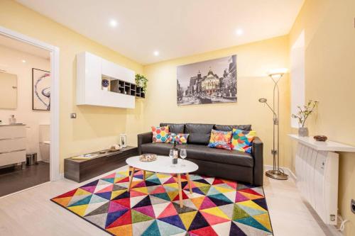 a living room with a couch and a colorful rug at Charming Plaza de España Central in Madrid