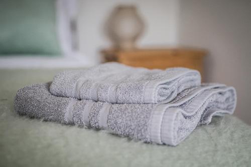 a pile of towels sitting on top of a bed at Seaview on the beach in Port Erin