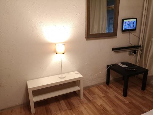 Zimmer mit einem Tisch und einer Lampe an der Wand in der Unterkunft NEXT TIME in Warschau