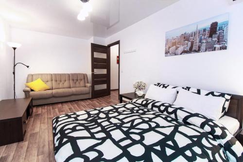 a bedroom with a black and white bed and a couch at Apartment on Soborniy 85 in Oleksandriya