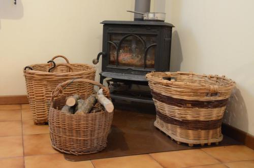 three baskets sitting on the floor next to a stove at B & B I BALBI in Sernaglia della Battaglia