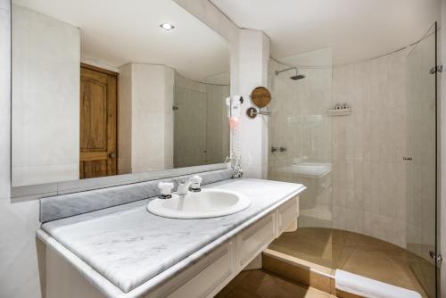 bagno bianco con lavandino e specchio di Hotel Egina Bogotá a Bogotá