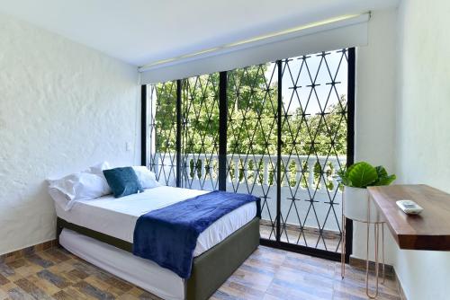 a bedroom with a bed and a large window at CABAÑAS LA DORADA in Doradal