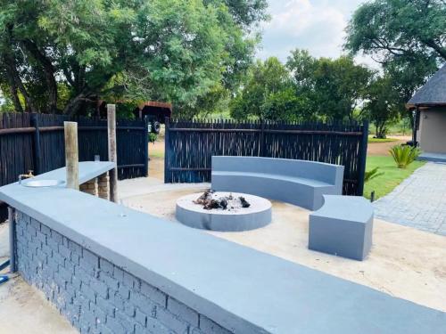 a patio with a blue bench and a fire pit at Sasavona Game Lodge in Warmbaths