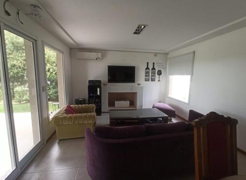 ein Wohnzimmer mit zwei Sofas und einem Fernseher in der Unterkunft Barrio cerrado premium in Dique Luján