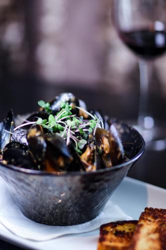 a bowl of food on a plate with a glass of wine at Pinnacle Hotel at the Pier in North Vancouver