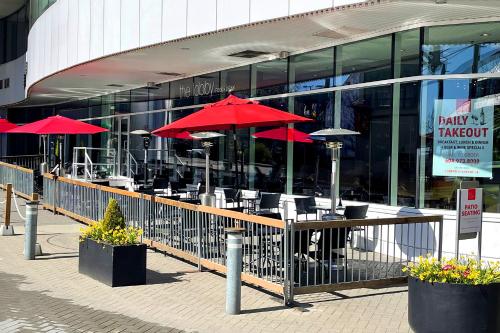 a restaurant with red umbrellas in front of a building at Pinnacle Hotel at the Pier in North Vancouver