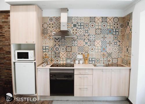 uma cozinha com um lavatório e uma parede de azulejos em Casa do Ferreiro em Sistelo