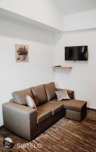 a brown couch in a living room with a tv at Casa do Ferreiro in Sistelo