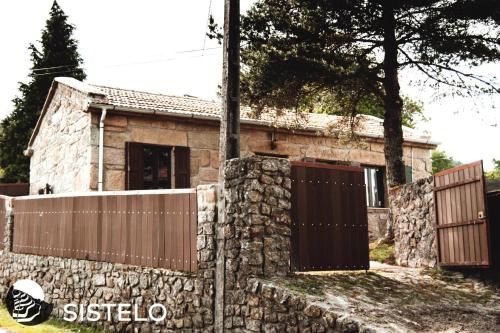 a stone house with two gates and a fence at Casa do Ferreiro in Sistelo