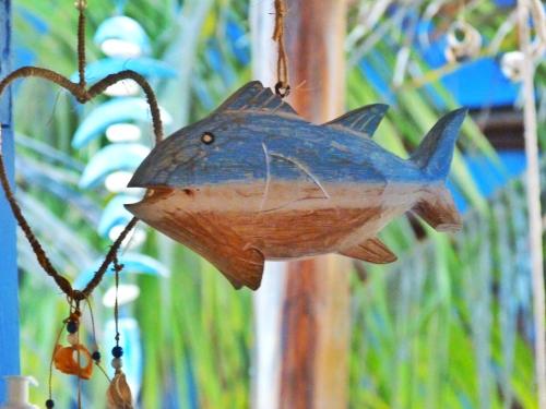 a wooden shark ornament hanging from a string at Pousada Casa Azul do Piauí in Luis Correia