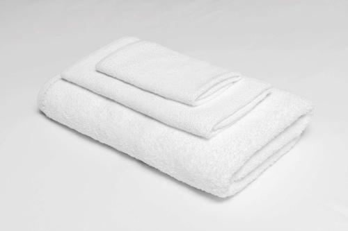 uma pilha de toalhas brancas sobre um fundo branco em GuestHouse Montesano em Montesano