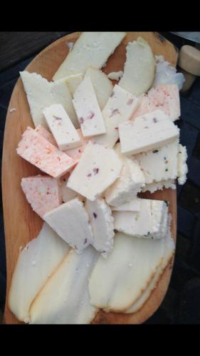 a pile of cheese on a wooden cutting board at Nyerges Lovasudvar in Cserépfalu