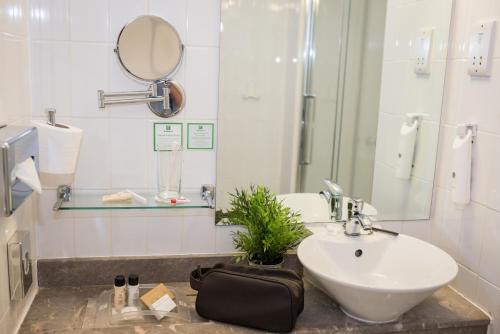 a bathroom with a sink, toilet, mirror and tub at Holiday Inn Manchester West, an IHG Hotel in Manchester