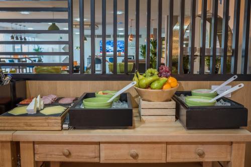 two trays of food on a table with a bowl of fruit at Holiday Inn Manchester West by IHG in Manchester