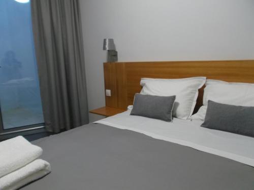a bedroom with a white bed with two pillows at Angra Downtown in Angra do Heroísmo