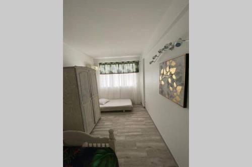- un couloir d'une chambre avec un canapé et une fenêtre dans l'établissement Bel Appartement lumineux, à Sainte-Luce