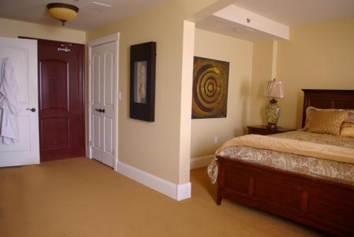 a bedroom with a bed and a painting on the wall at Grant Hall Hotel in Moose Jaw