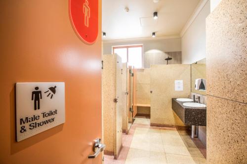 a bathroom with a sink and a toilet stall at Ramsgate Hotel by Nightcap Social in Adelaide
