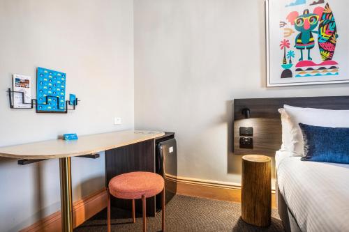 a bedroom with a bed and a desk next to a bed at Ramsgate Hotel by Nightcap Social in Adelaide