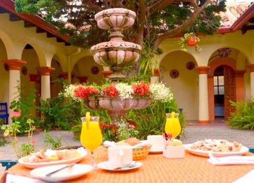 einen Tisch mit Teller mit Speisen und einem Brunnen in der Unterkunft Hotel Rincon Del Arco in San Cristóbal de las Casas
