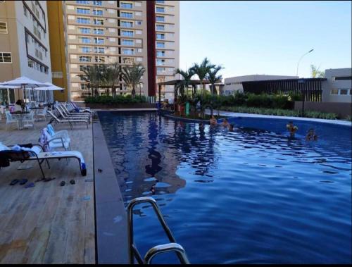 a swimming pool in a hotel with people in it at Evian Thermas Residence - Caldas Novas in Caldas Novas