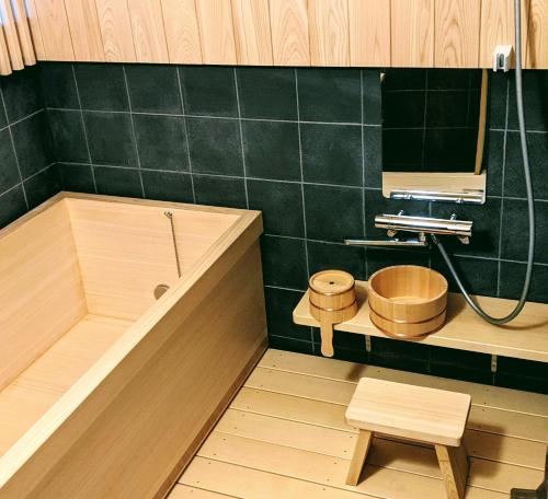 a bathroom with a tub and a toilet and a mirror at さいの郷「椛」 in Kagamino