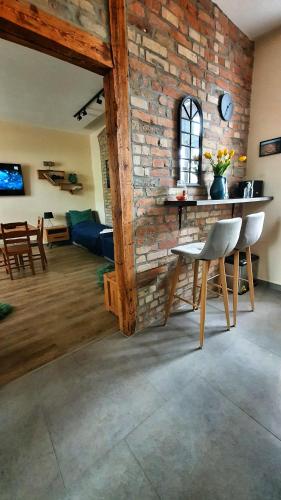 a living room with a brick wall and a table and chairs at Magiczne Mieszkanko in Piła