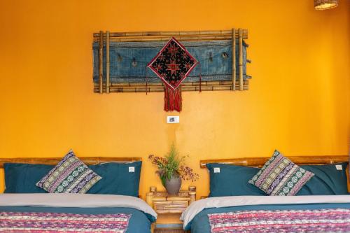 a bedroom with two beds and an orange wall at Mega View Homestay in Sa Pa