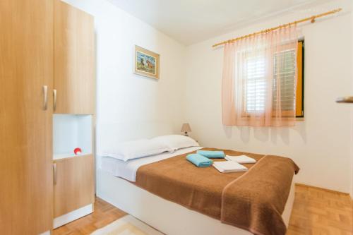 1 dormitorio con cama y ventana en House Pansy, en Pašman