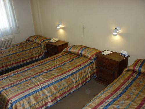 a hotel room with two beds and a telephone at Hotel Puerta del Sol in Mendoza
