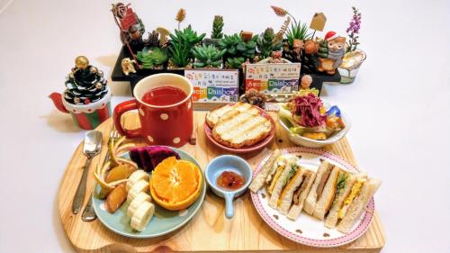 a wooden table topped with plates of food and fruit at Sweet Rainbow B&B in Hualien City