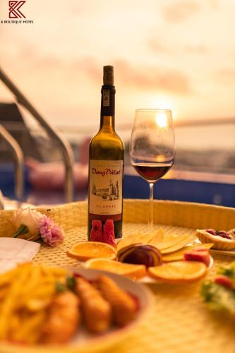 a bottle of wine sitting next to a glass of wine at TTR Skypool View Hotel in Da Lat
