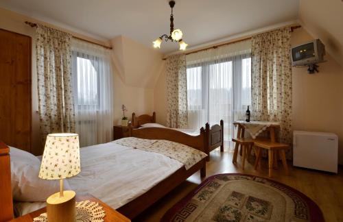 a bedroom with two beds and a table with a lamp at Michałowa Chata in Poronin