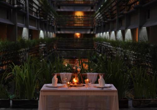 a table with candles on it in a room with plants at Greenhost Boutique Hotel Prawirotaman in Yogyakarta