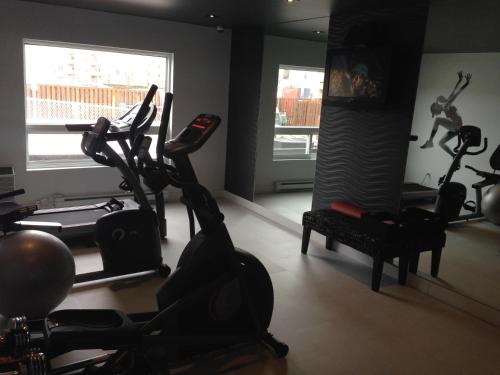 a gym with two exercise bikes and a treadmill at Hotel V in Gatineau