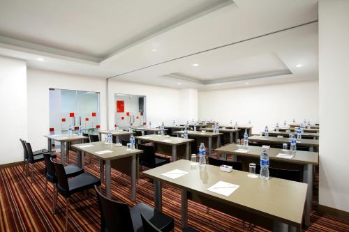 a large room with tables and chairs with water bottles at Amaris Hotel Season City in Jakarta