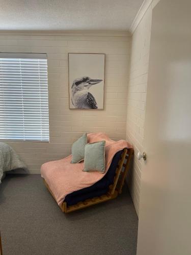 a bedroom with a bed with a bird picture on the wall at Stella Maris in Eden