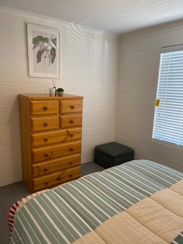 a bedroom with a bed and a dresser and a window at Stella Maris in Eden