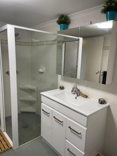 a white bathroom with a sink and a shower at Stella Maris in Eden