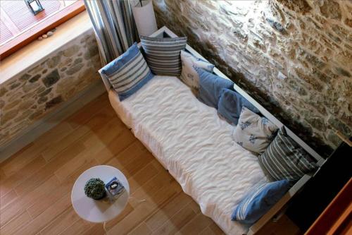 a couch with pillows and a table in a living room at Traditional Stone House at Great Location in Koroni