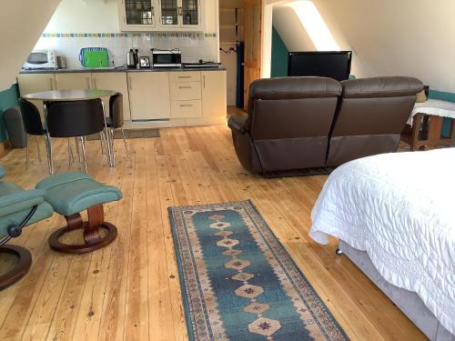 a bedroom with a bed and a couch and a kitchen at Studio in Tibberton