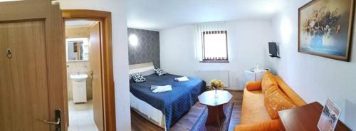 a bedroom with a blue bed and a bathroom at Ubytovanie na súkromí KIKA in Santovka