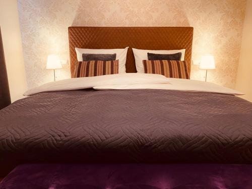 a bedroom with a large bed with two lamps at Hotel Tortuga & Tex-Mex Bar & Grill in Grafenwöhr